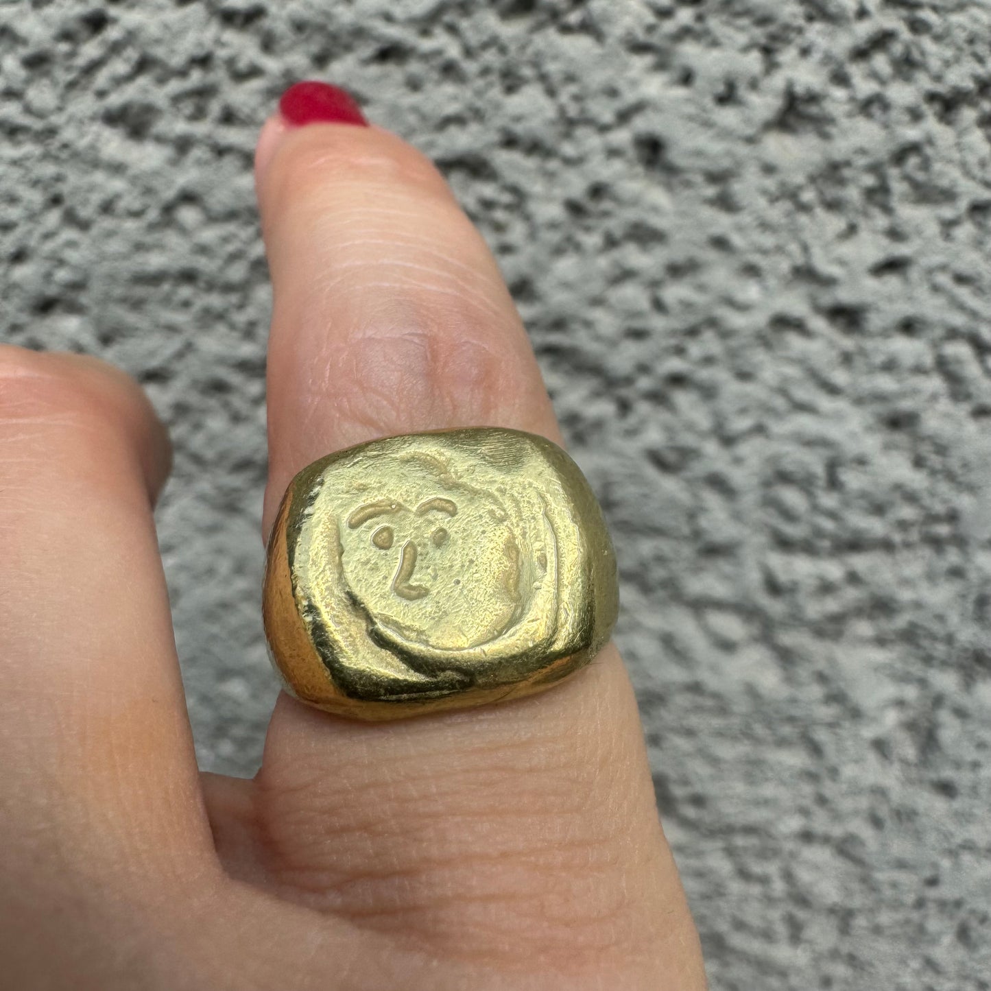 18K gold chunky gold ring with a rustic, organic finish, featuring an engraved abstract face motif at its center.