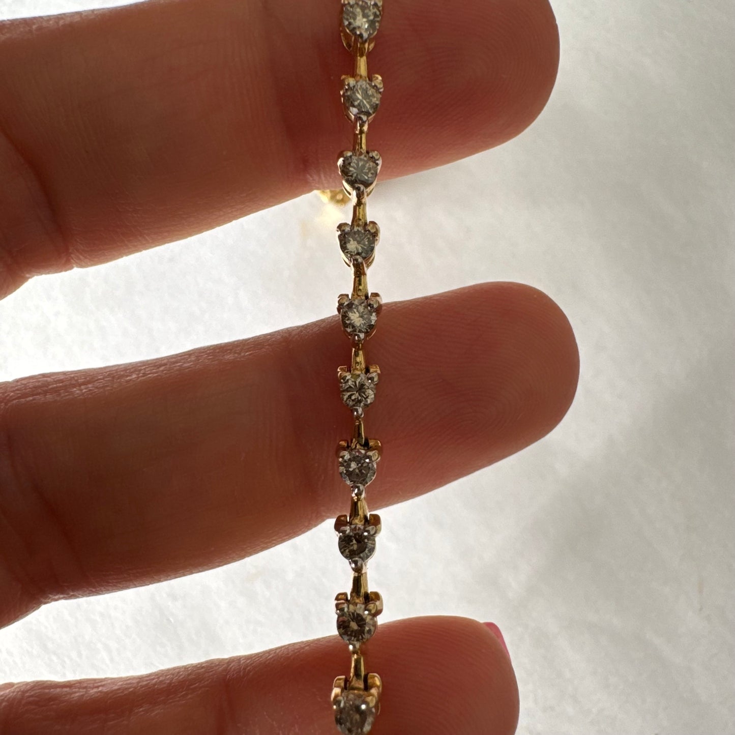 צמיד טניס מזהב צהוב 14 קראט משובץ שורת יהלומים, היוצרים ברק רציף ומראה נקי ועל-זמני.