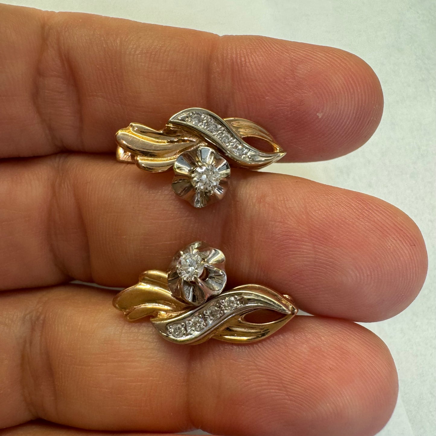 עגילי זהב 14 קראט בעיצוב מתעגל ואלגנטי המשובצים יהלומים נוצצים .