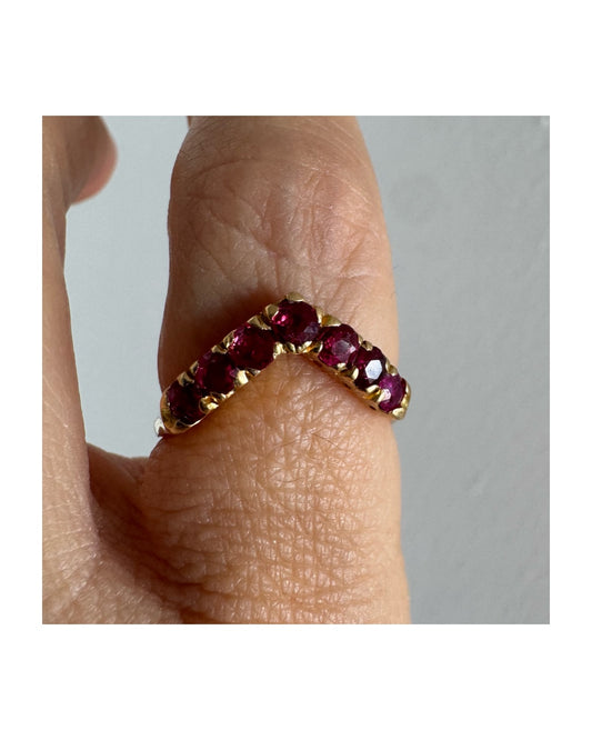 18K gold ring set with vivid red rubies in a distinctive V-shaped design.