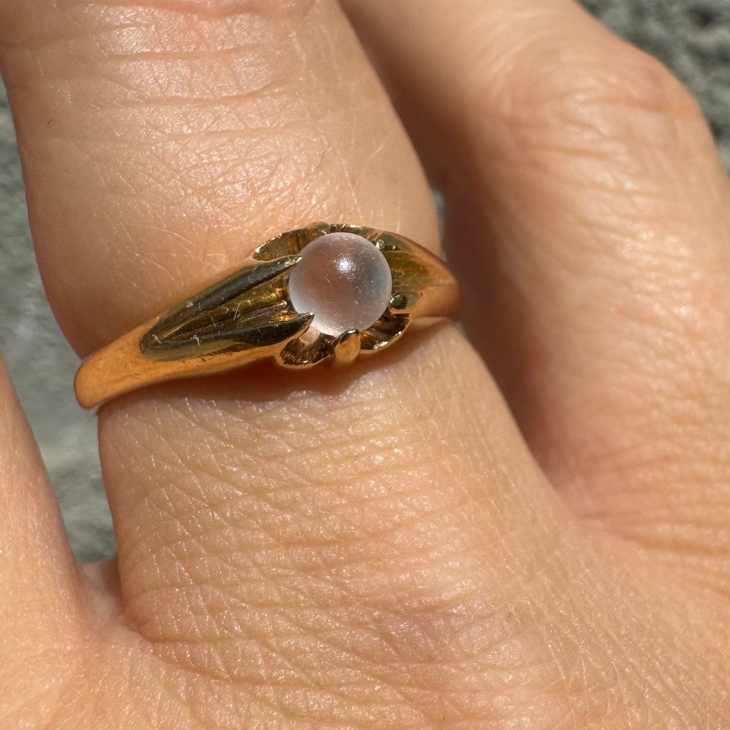 18K yellow gold ring featuring a smooth round Moonstone set in a delicate floral-inspired design.
