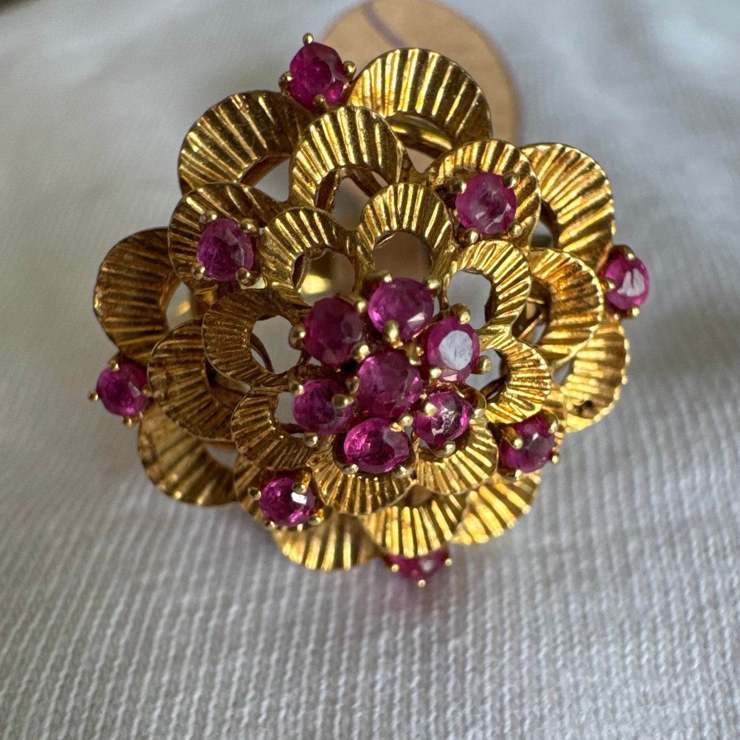 טבעת זהב צהוב 18 קראט, מעוטרת באבני רובי קטנות בצבע ורוד-אדום.