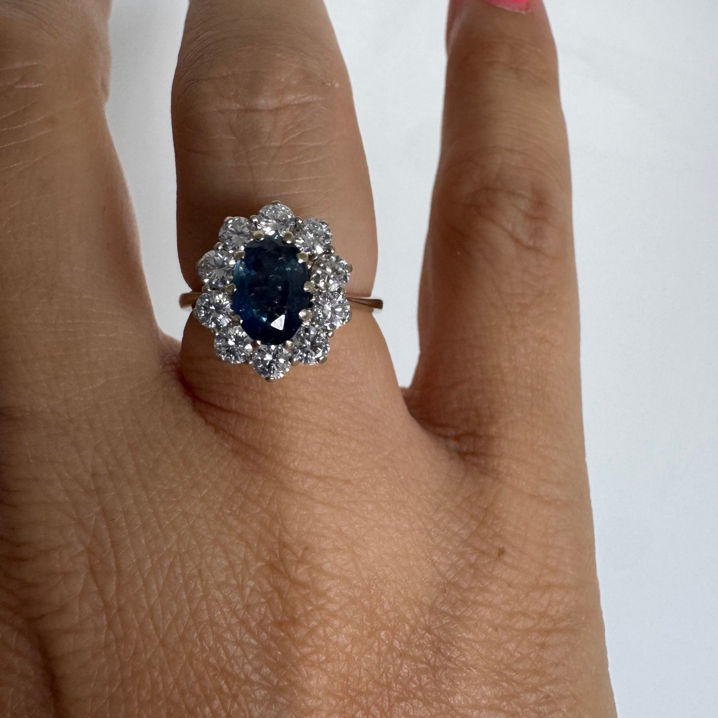 18K gold ring featuring a deep blue Sapphire at its center, surrounded by a sparkling halo of Diamonds
