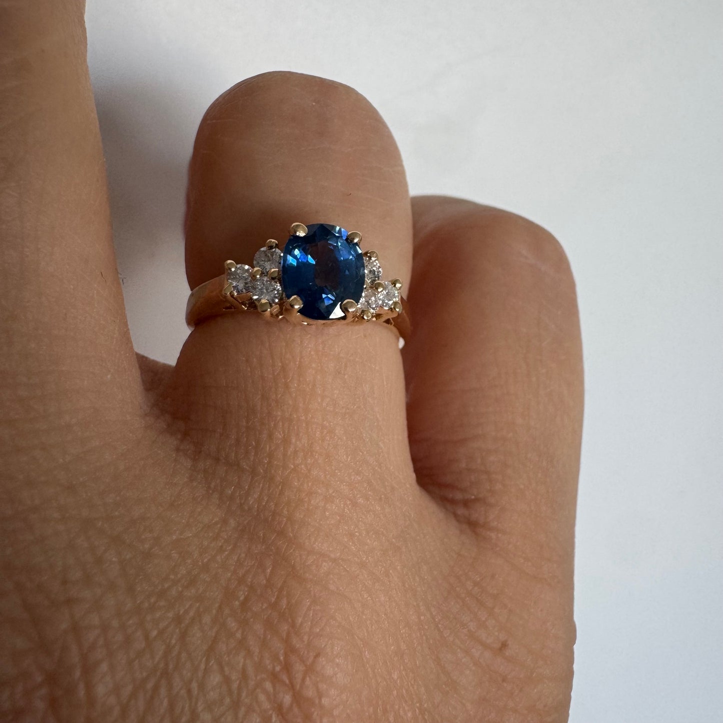 14K gold ring set with an oval blue Sapphire at the center & Diamonds