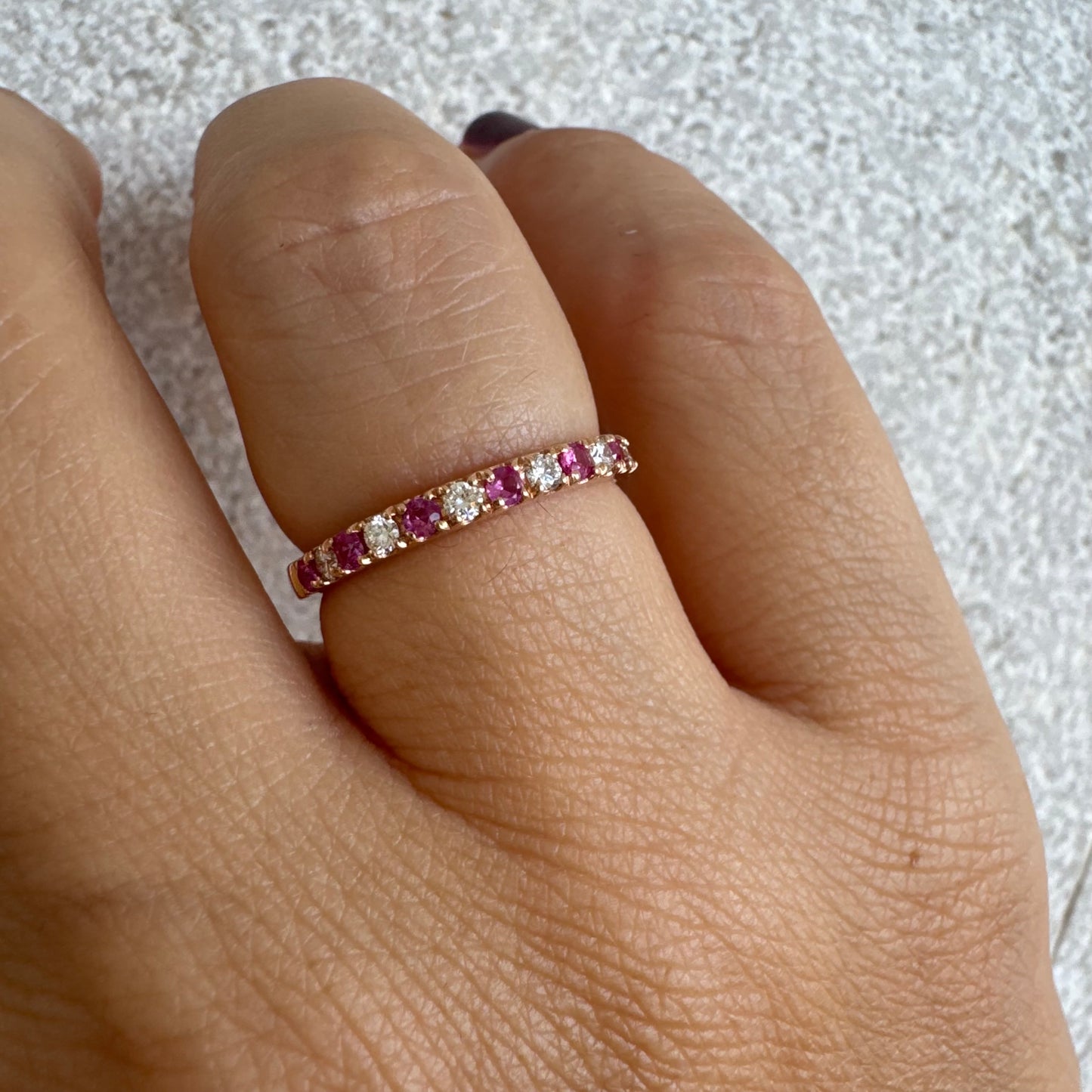 טבעת חצי איטרניטי מזהב אדום 14 קראט, משובצת ברצף של אבני רובי ויהלומים .