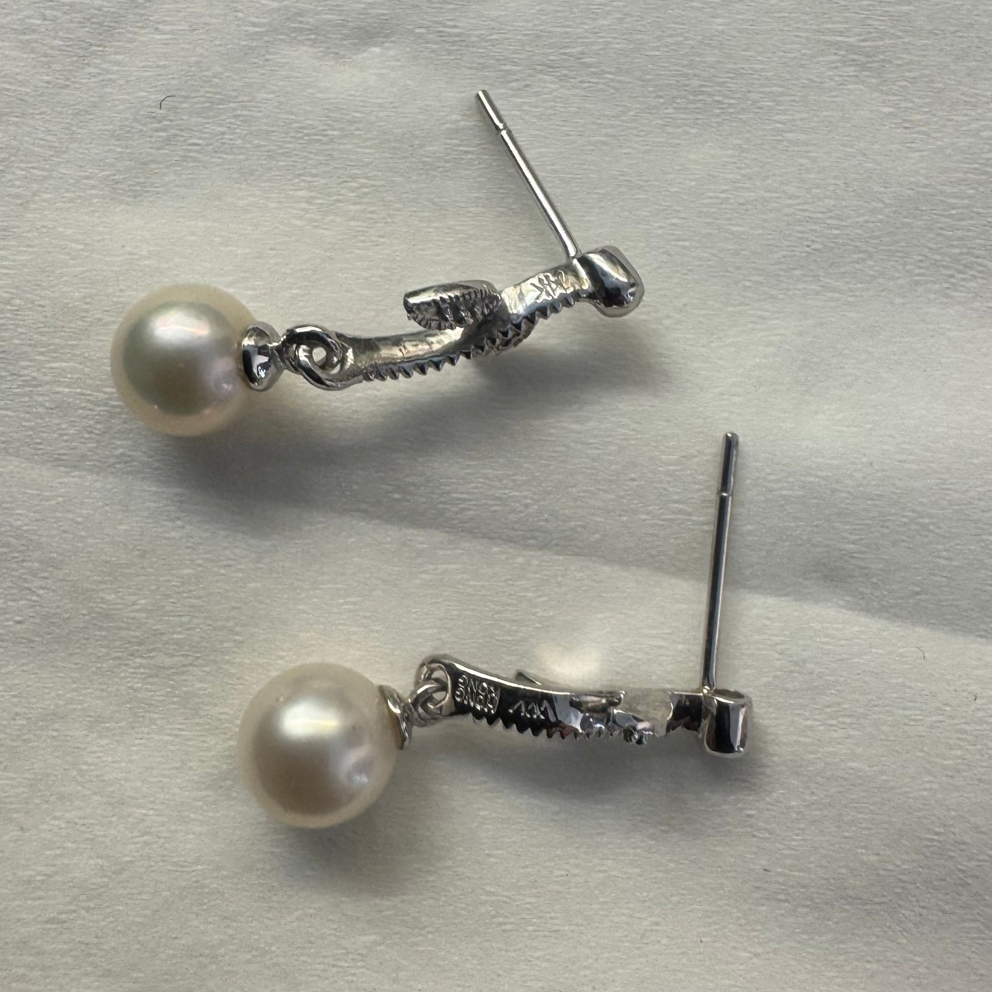 14K gold drop earrings designed with delicate leaf details, each holding a round white Pearl.