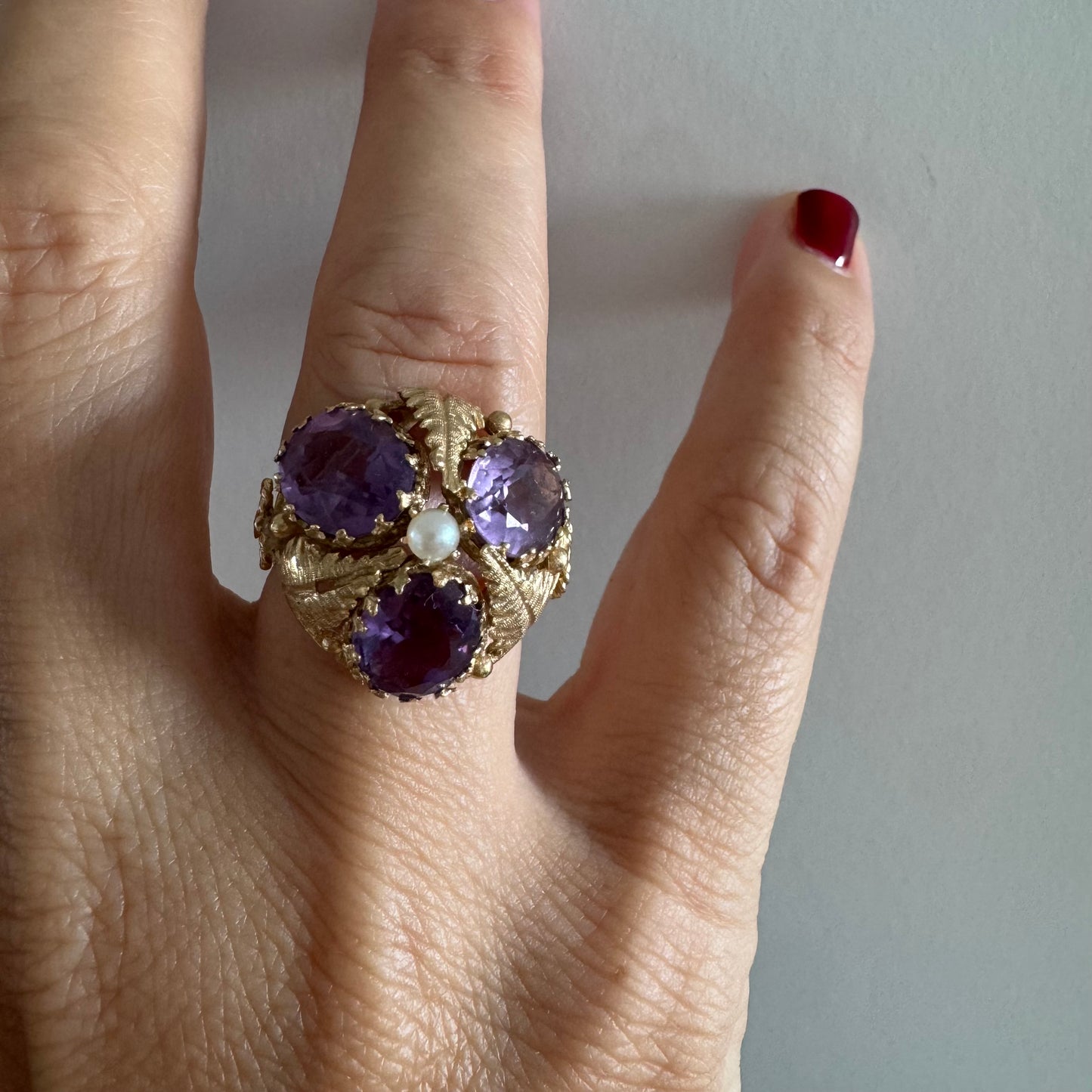14K gold ring set with four glowing Amethyst stones encircling a delicate central Pearl.