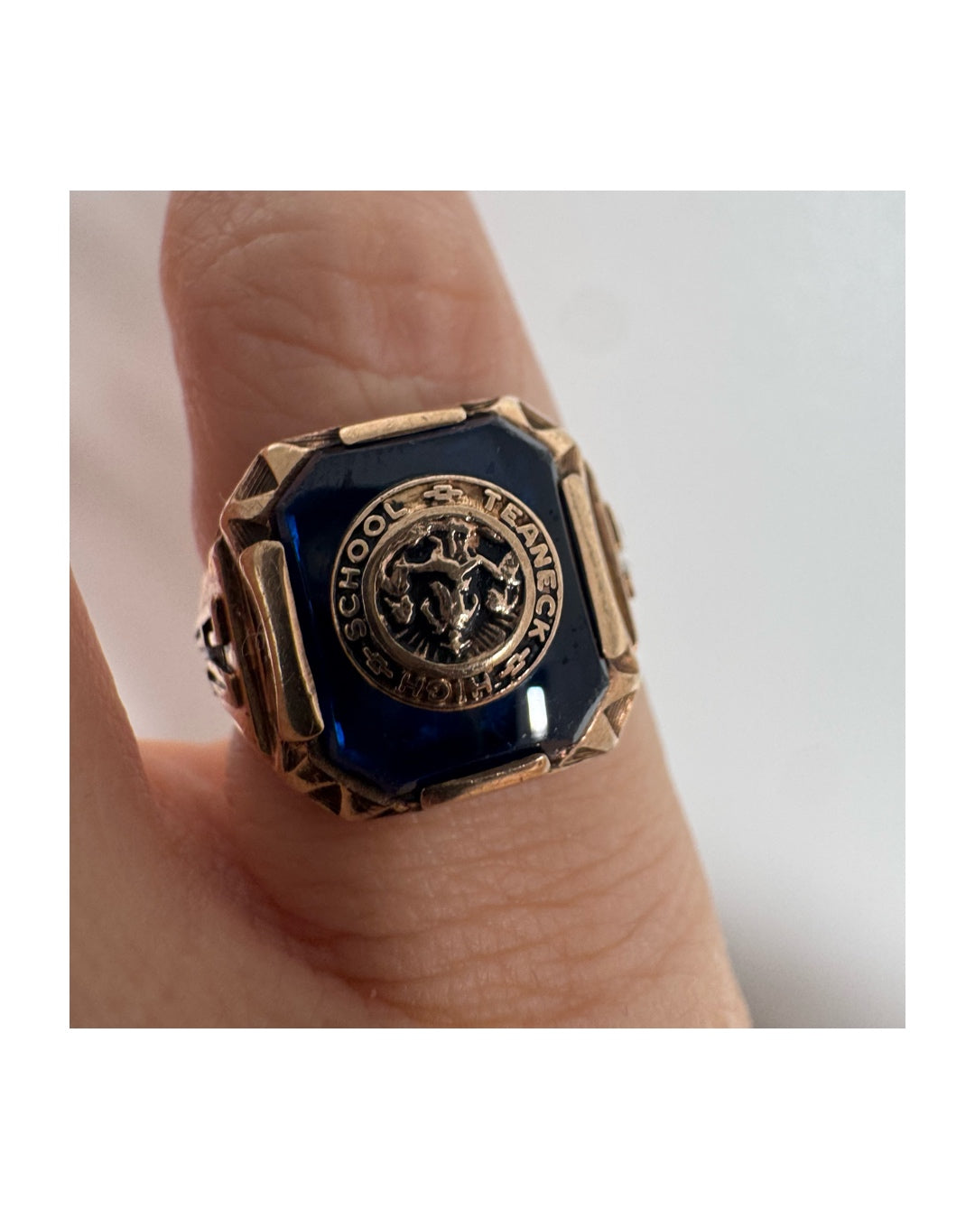 10K gold signet-style ring featuring a deep blue stone set with a raised “School & Teamwork” emblem at the center.