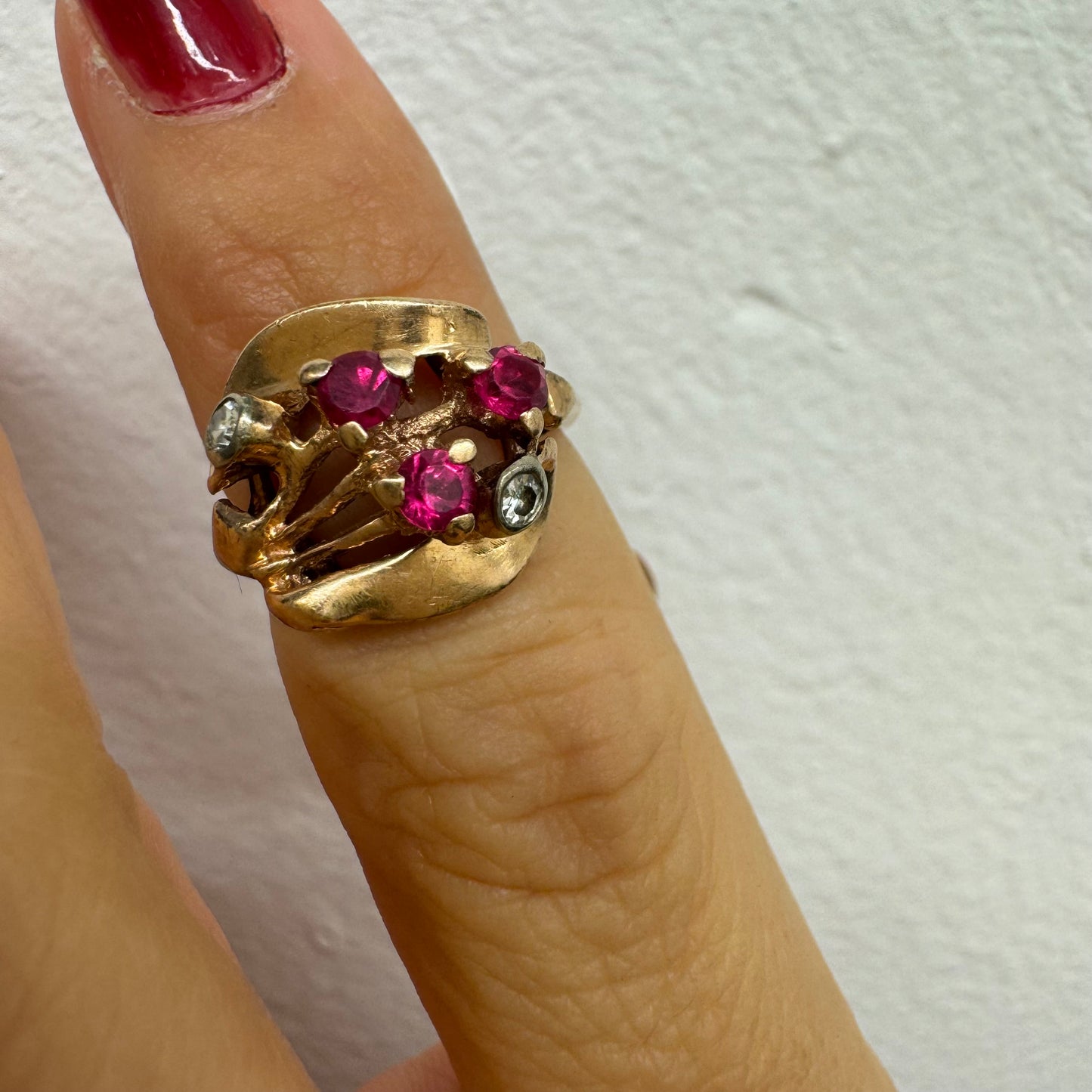 טבעת זהב צהוב 14 קראט, משובצת אבני רובי ושני יהלומים להדגשה, בעיצוב פיסולי ומלא אופי.