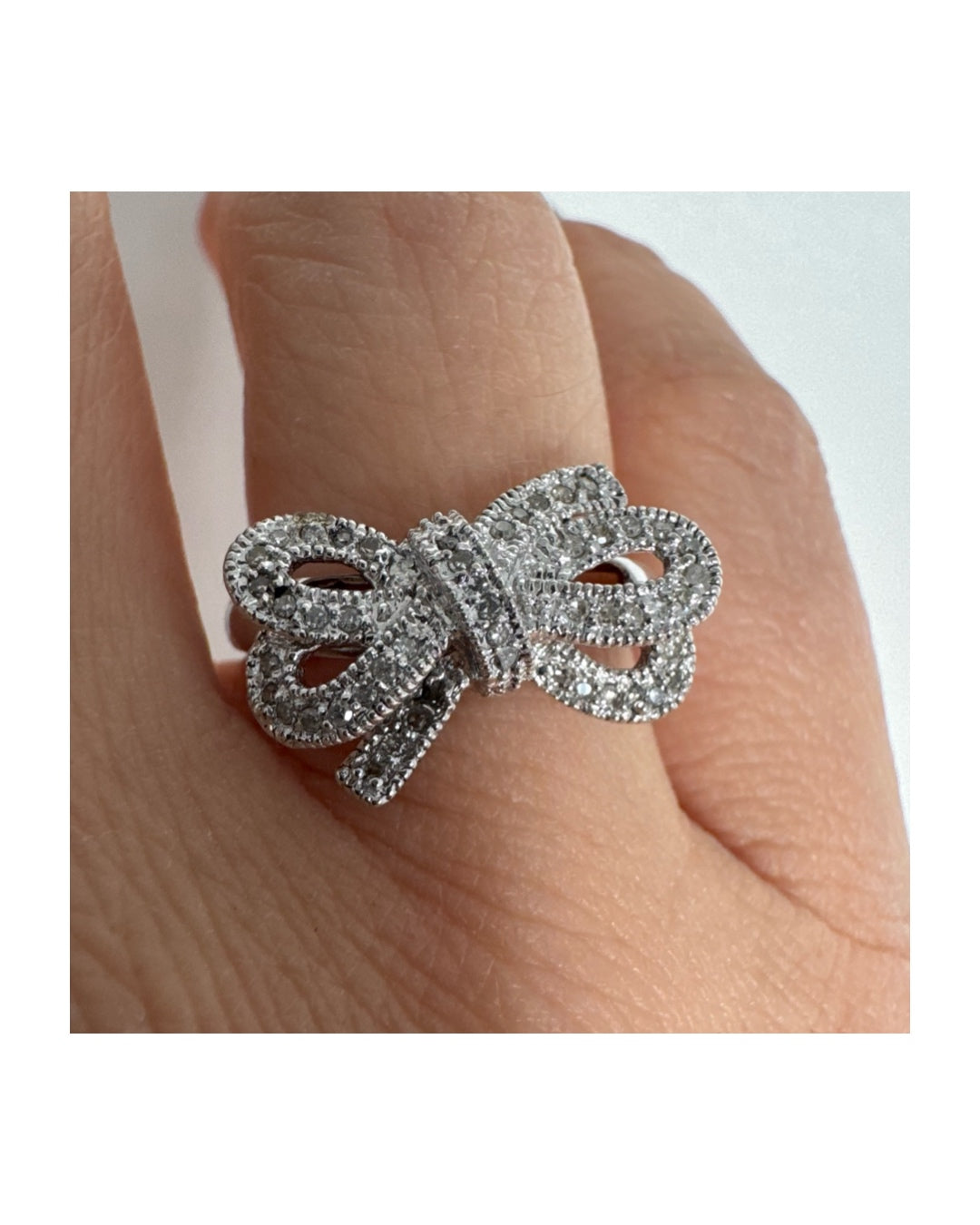 טבעת זהב לבן 14 קראט מעוצבת בצורת פפיון ומשובצת יהלומים בשיבוץ פאבה צפוף.