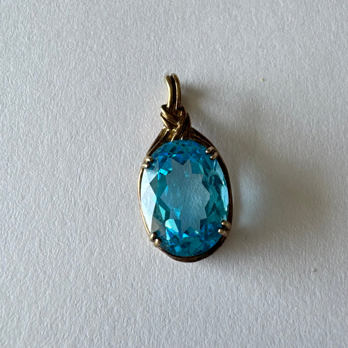 9K gold Pendant set with a striking oval-cut Blue Topaz