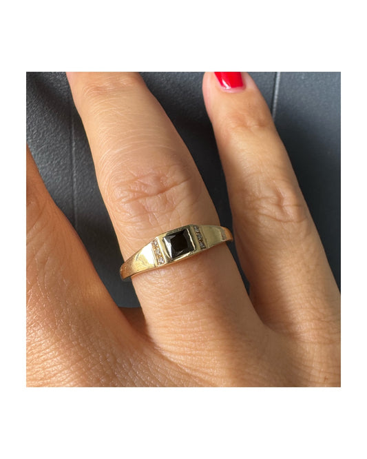 טבעת זהב 14 קראט משובצת אבן ספינל שחור בחיתוך ריבועי במרכז ויהלומים קטנים משני הצדדים.