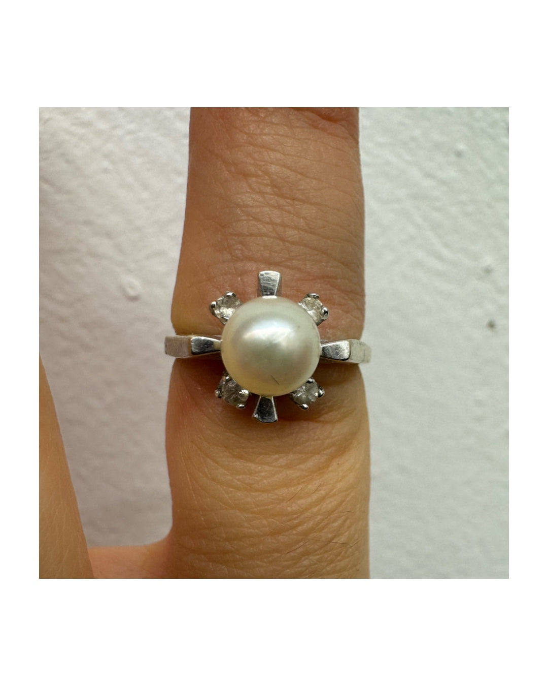 10K white gold ring set with a central Pearl surrounded by Diamonds.