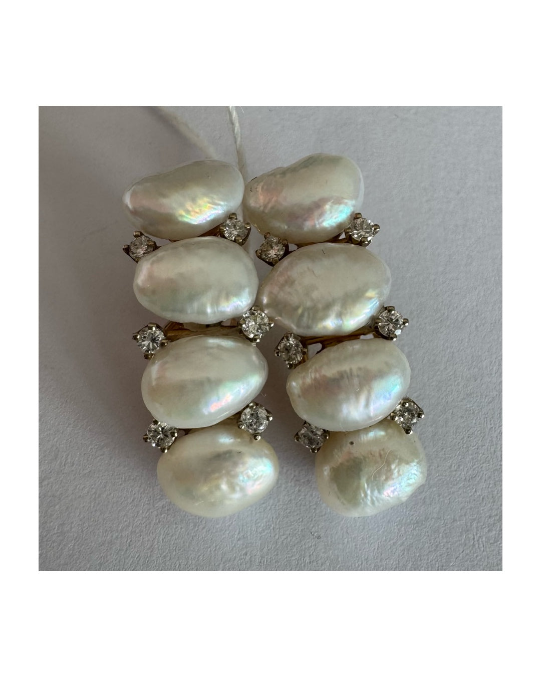 14K gold clip-on earrings set with Pearls accented by sparkling Diamonds between each pearl