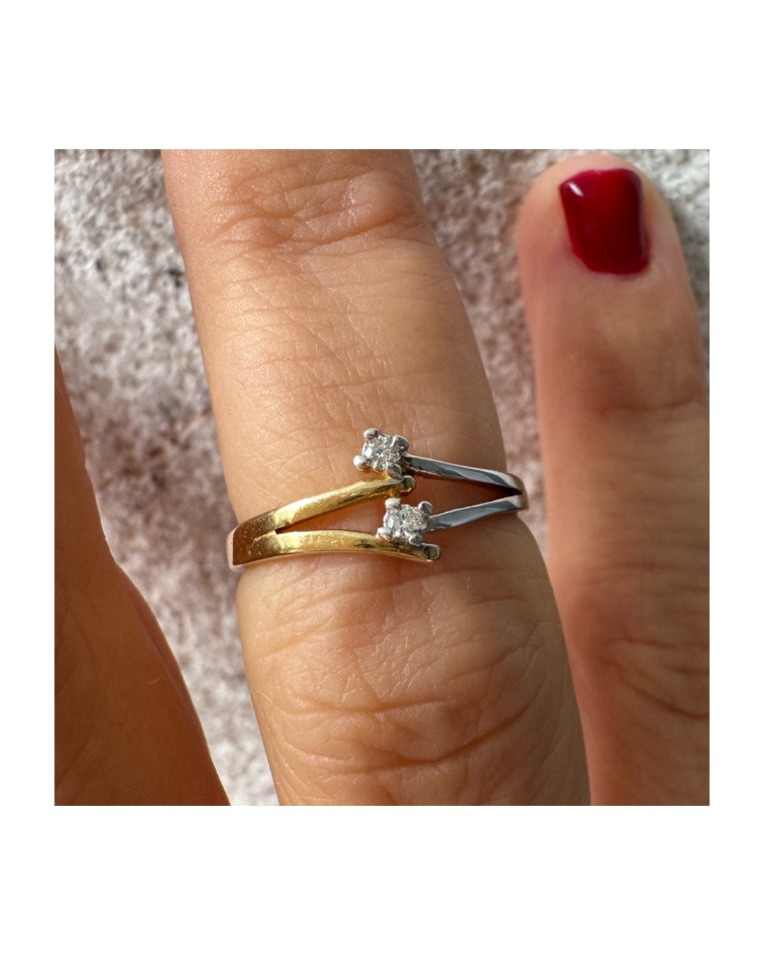 טבעת זהב 14 קראט, עם זרועות מצטלבות בזהב צהוב וזהב לבן, שכל אחת מהן משובצת יהלום קטן ונוצץ.