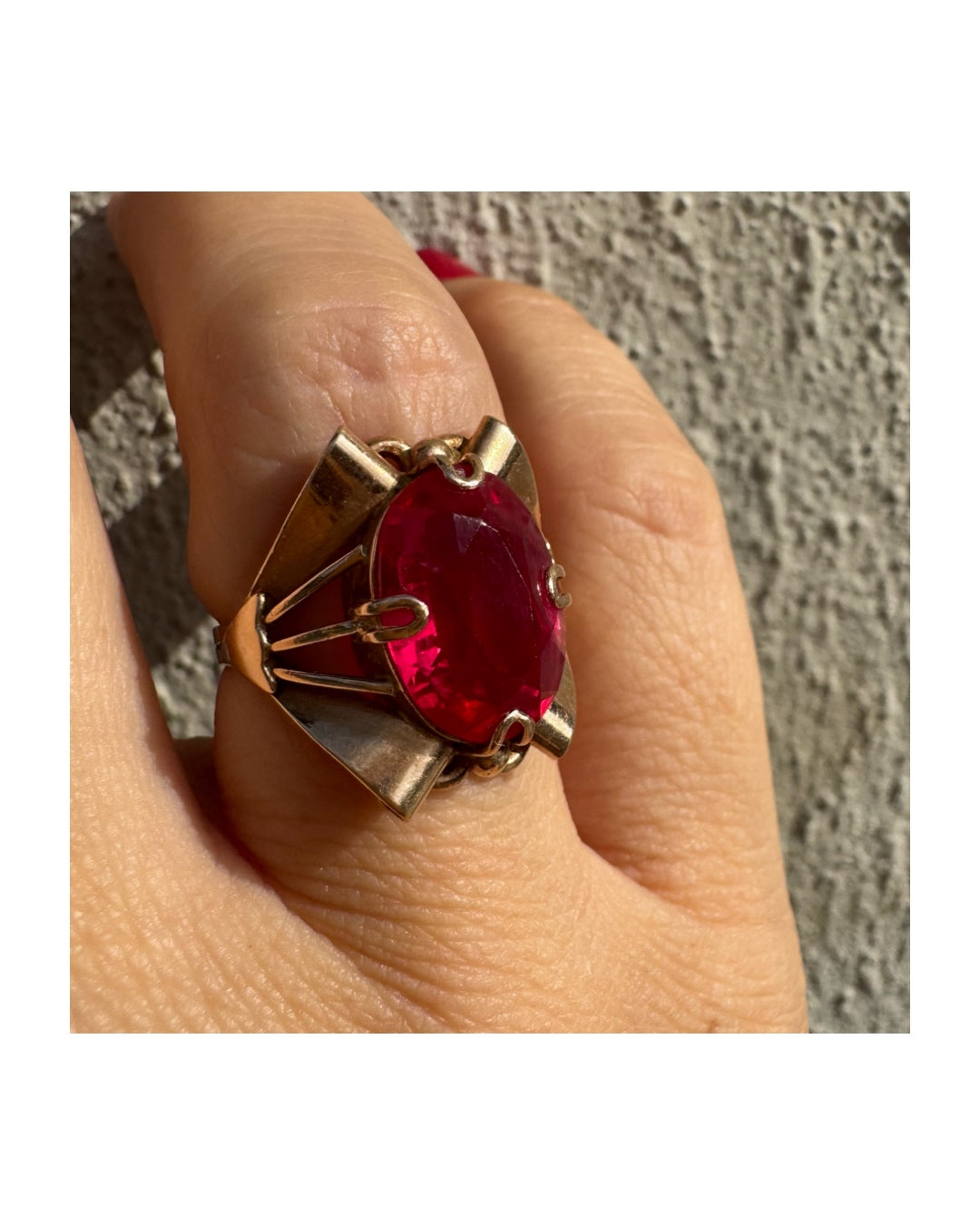 טבעת זהב 14 קראט משובצת אבן אובלית גדולה בצבע אדום חי במסגרת גאומטרית מיוחדת.