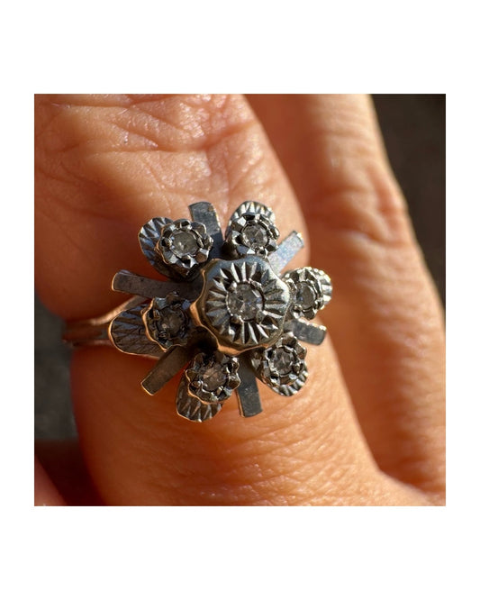 טבעת פרחונית זהב לבן 18 קראט משובצת בנגיעות יהלומים עדינות.