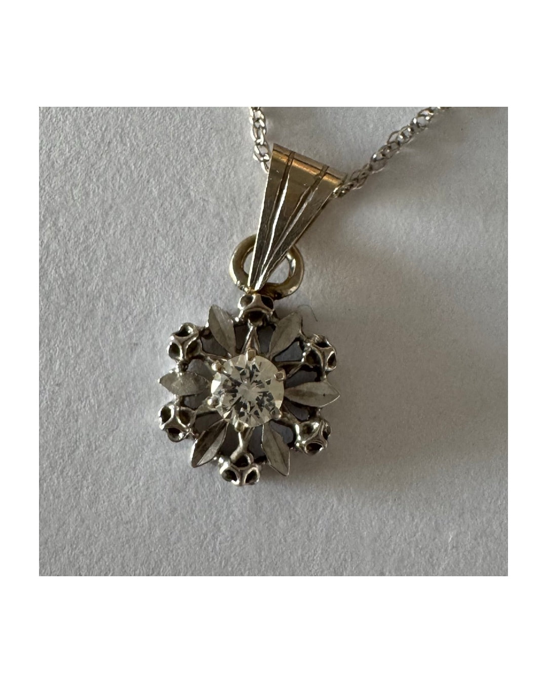 14K gold pendant set with a central Diamond, designed in a delicate flower motif