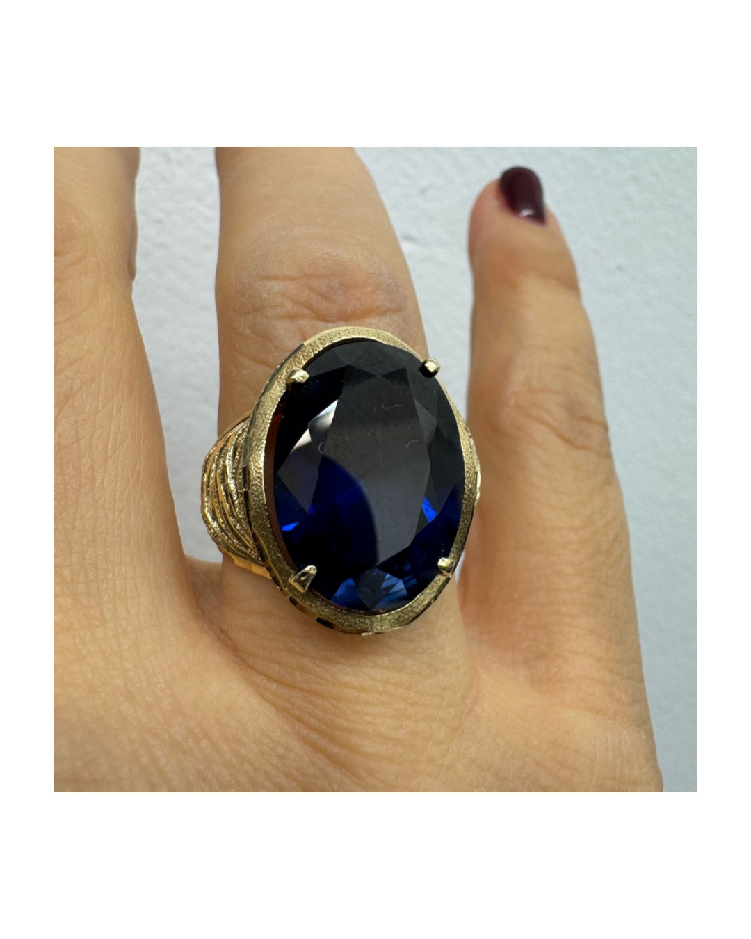 טבעת זהב צהוב 14 קראט משובצת אבן ספיר בחיתוך אובלי ובסיס מזהב עם עיטורי תבליט דמויי גלים