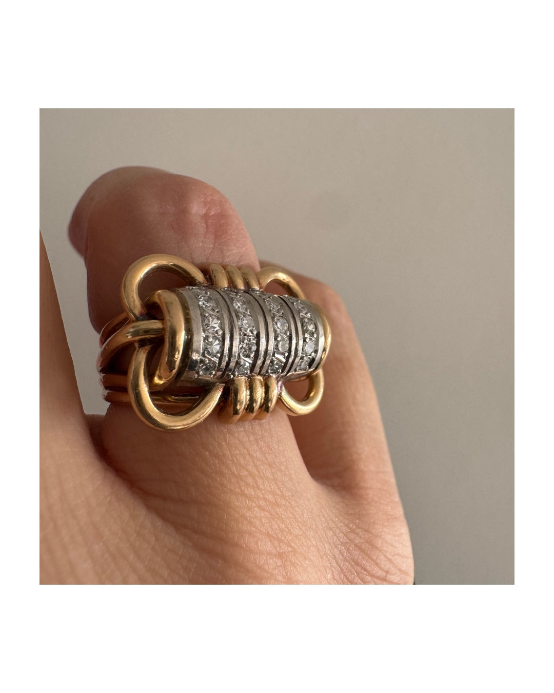 טבעת זהב צהוב ולבן 18 קראט עם מרכז בצורת חבית, משובצת יהלומים נוצצים.