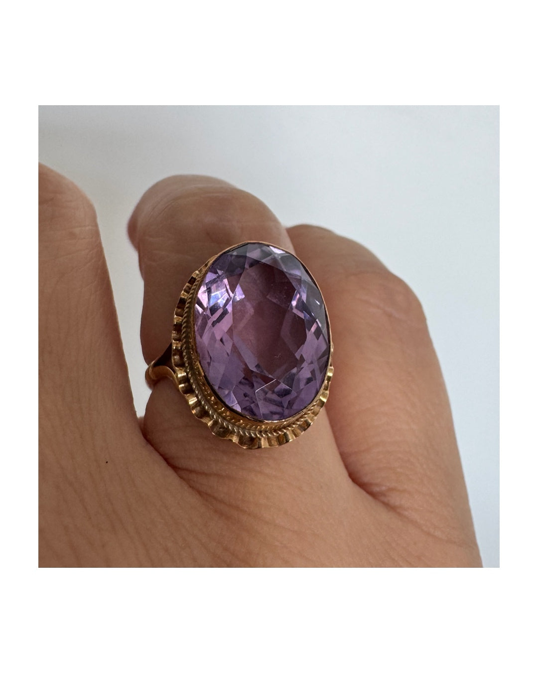14K gold ring featuring a large oval-cut Amethyst set in an beautifully detailed gold setting