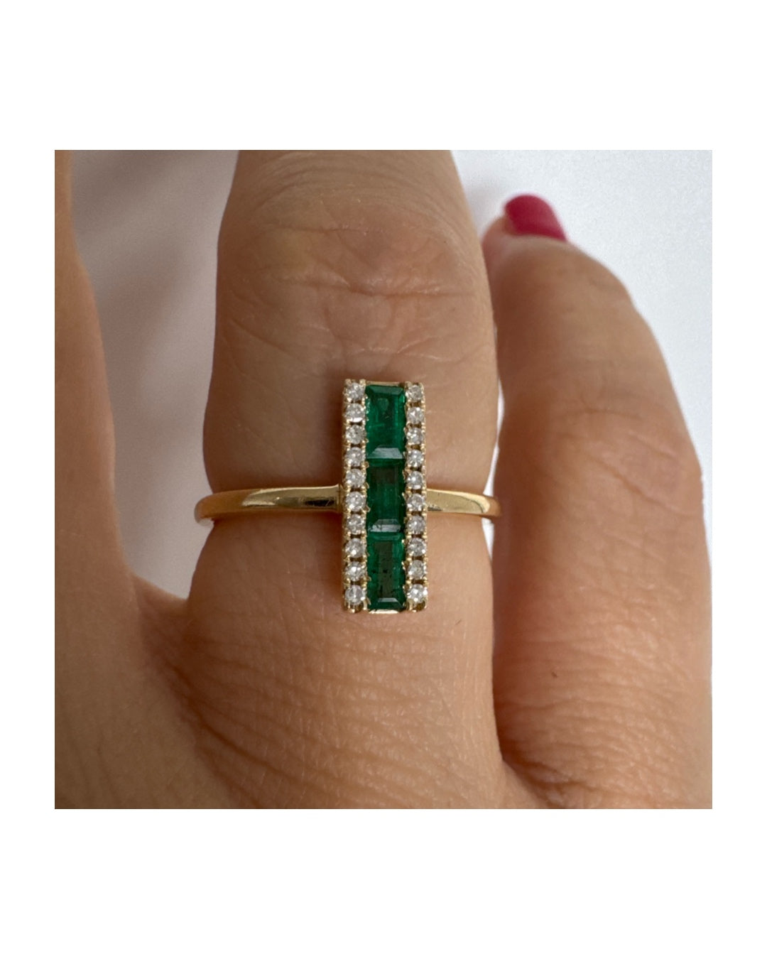 14K gold ring set with baguette-cut Emeralds framed by two rows of sparkling Diamonds